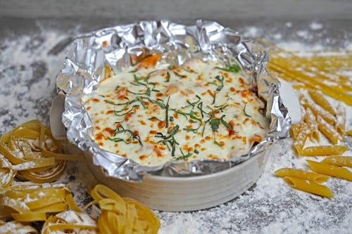 A cheese and pasta dish in foil with some herbs