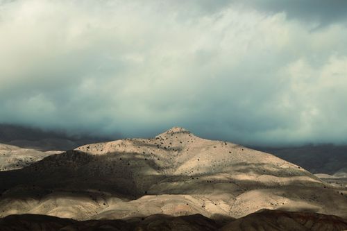 Free A breathtaking view of hills with dramatic cloud coverage and shadows in natural light. Stock Photo