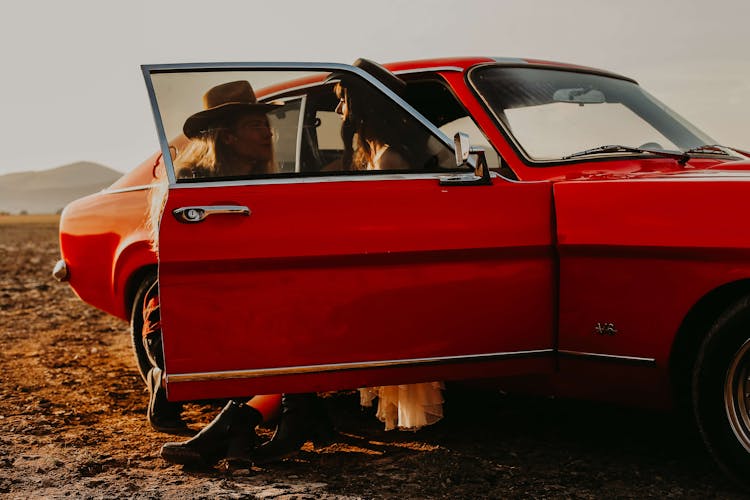 Couple Wearing Cowboy Hats In Vintage Car