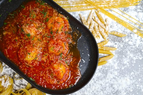 A pan filled with meatballs and pasta