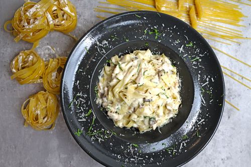 Free Delicious bowl of creamy fettuccine pasta topped with Parmesan cheese, perfect for a gourmet meal. Stock Photo