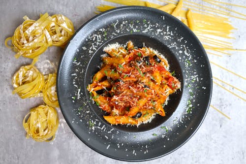 A plate of pasta with sauce and spaghetti