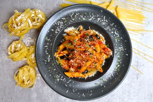 Free A vibrant Italian pasta dish with rich tomato sauce and fresh herbs, perfect for food lovers. Stock Photo