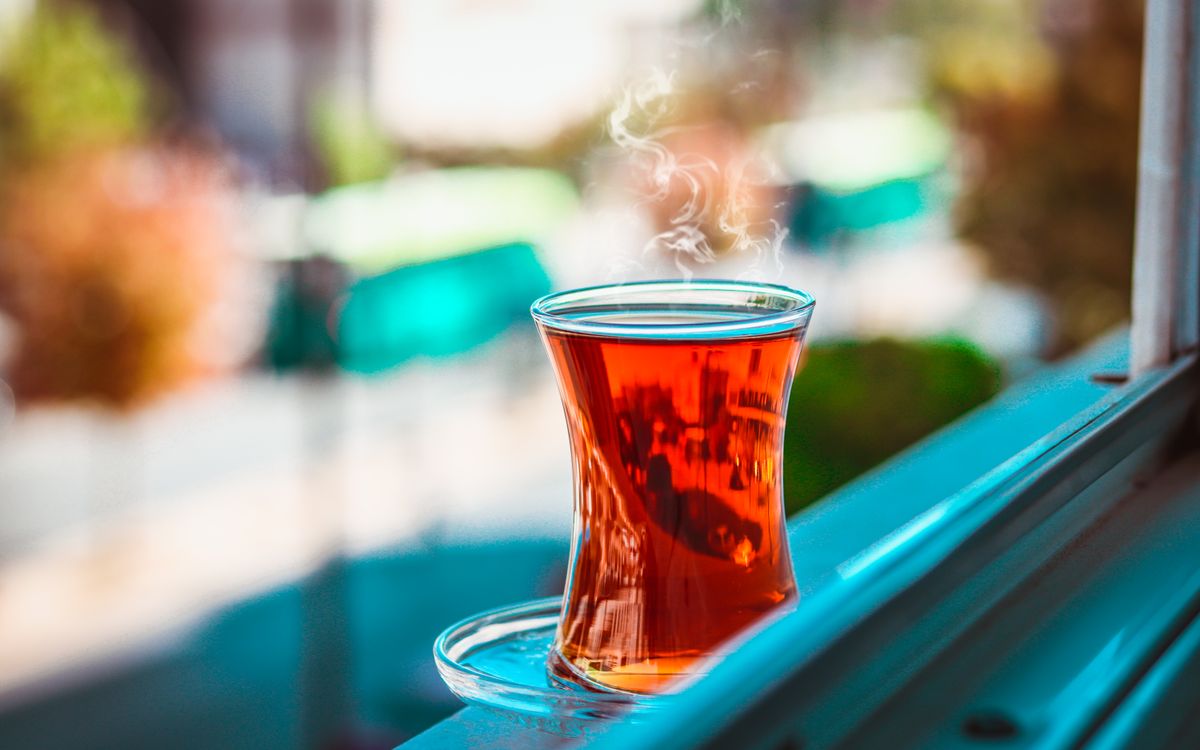 A steaming cup of Turkish tea on a windowsill with blurred background in Gaziantep.