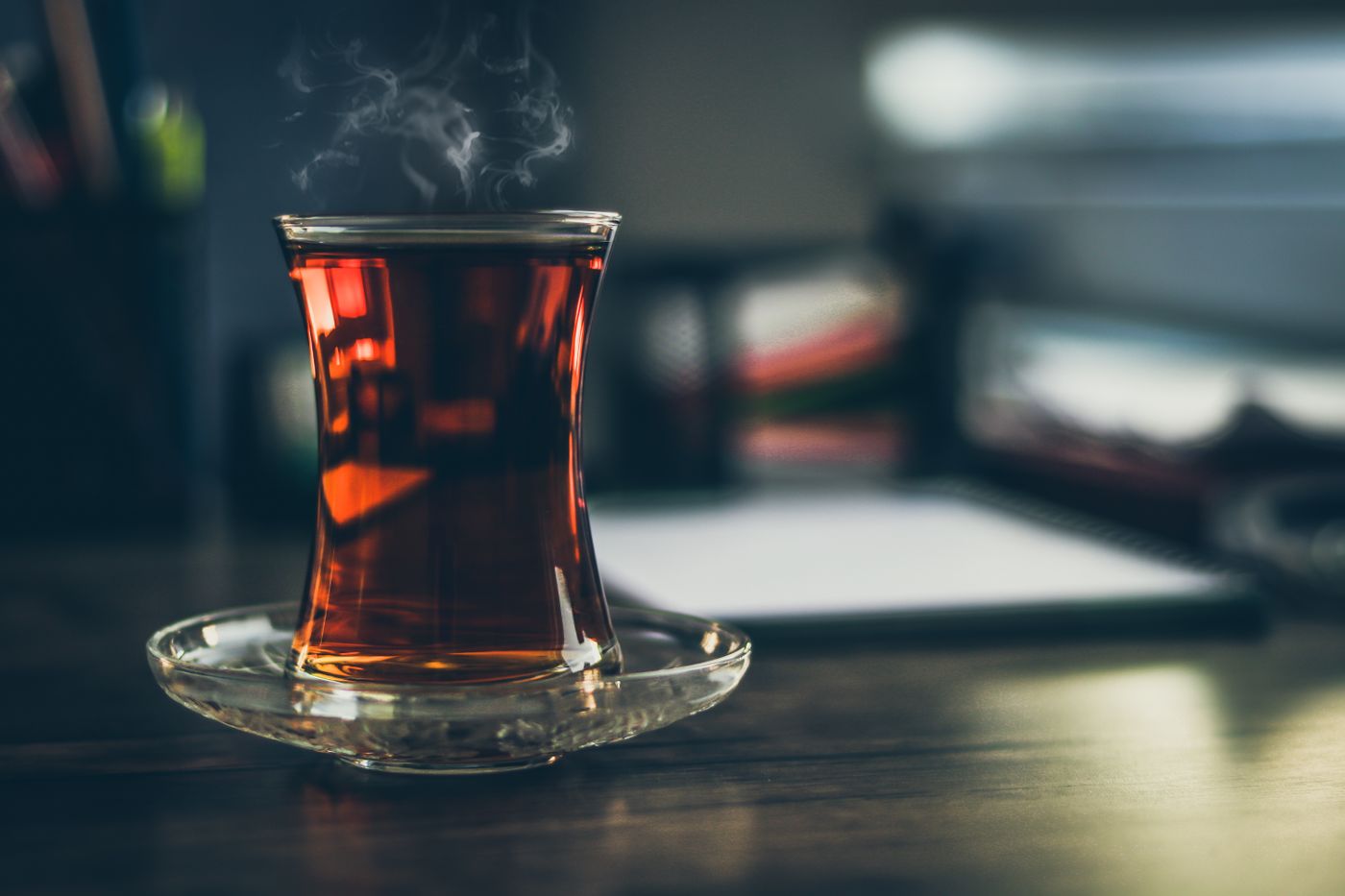 Steaming black tea served in a clear glass.