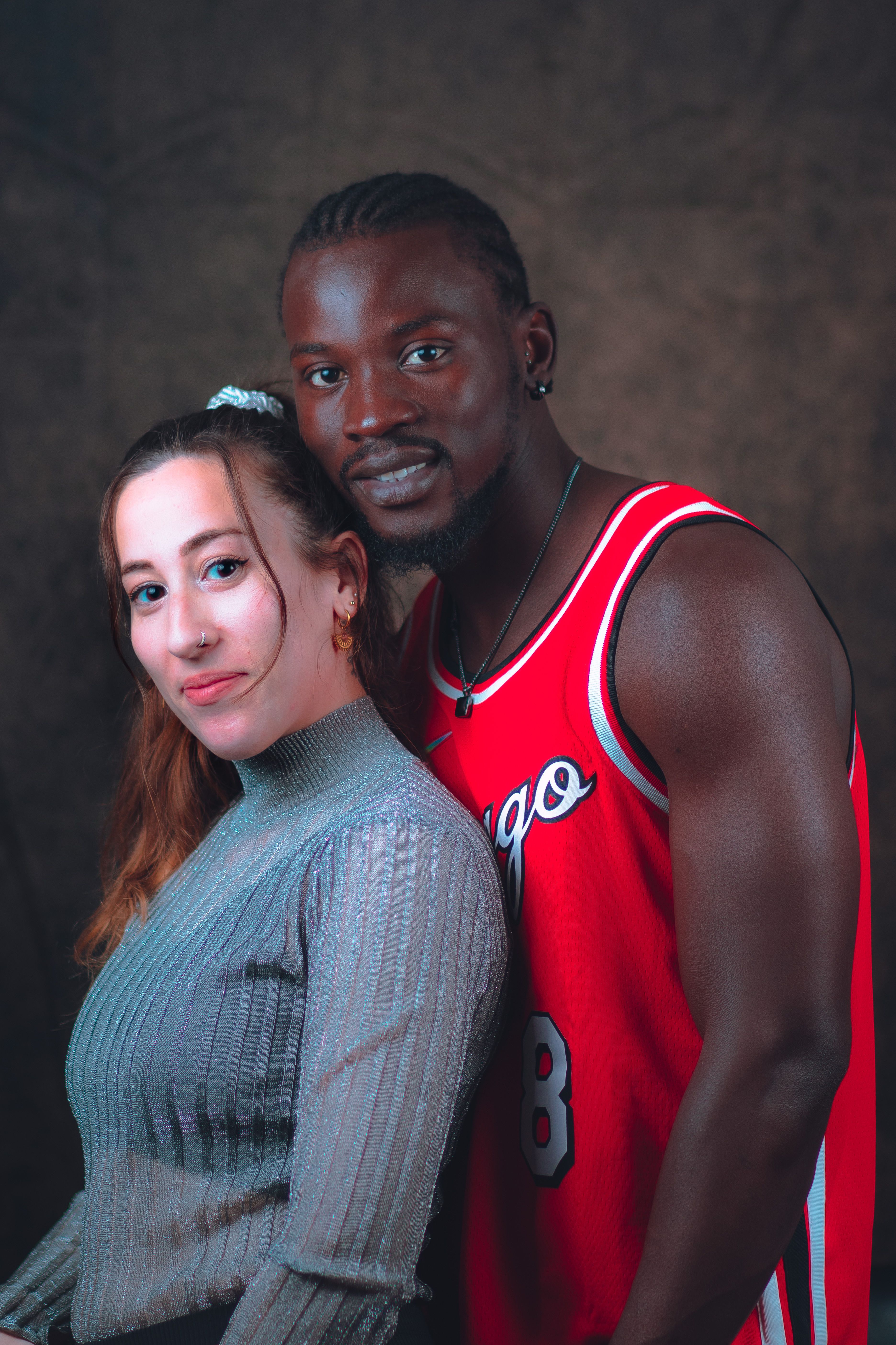 Close-up portrait of a happy couple, showcasing affection and warmth in a studio setting.