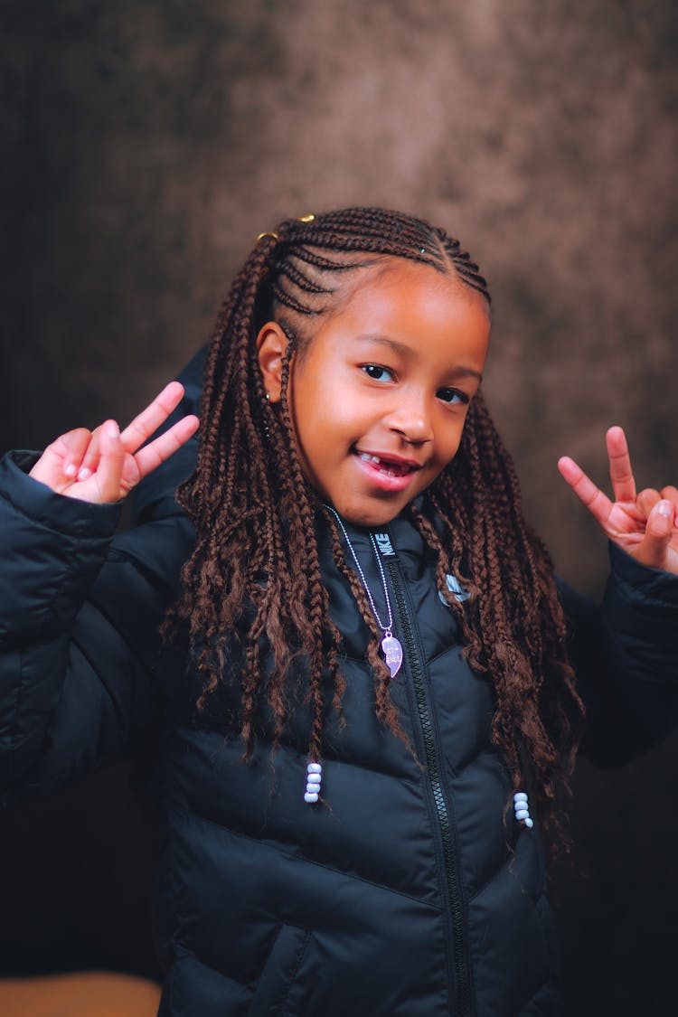 A Girl In A Jacket Doing  A V Sign 