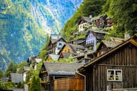 在奥地利哈尔施塔特，一座迷人的木屋坐落在郁郁葱葱的山腰上，沐浴在明亮的日光中