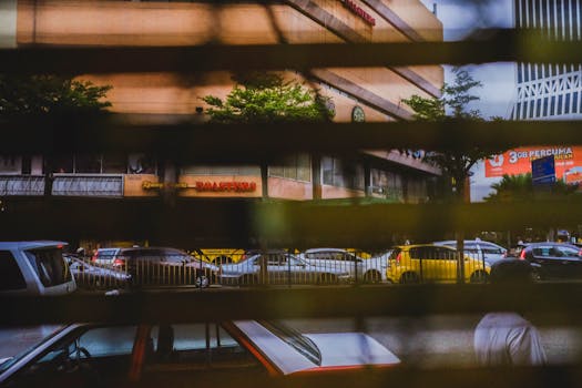 透过百叶窗，可以捕捉到马来西亚彭亨市的城市交通和建筑物街景