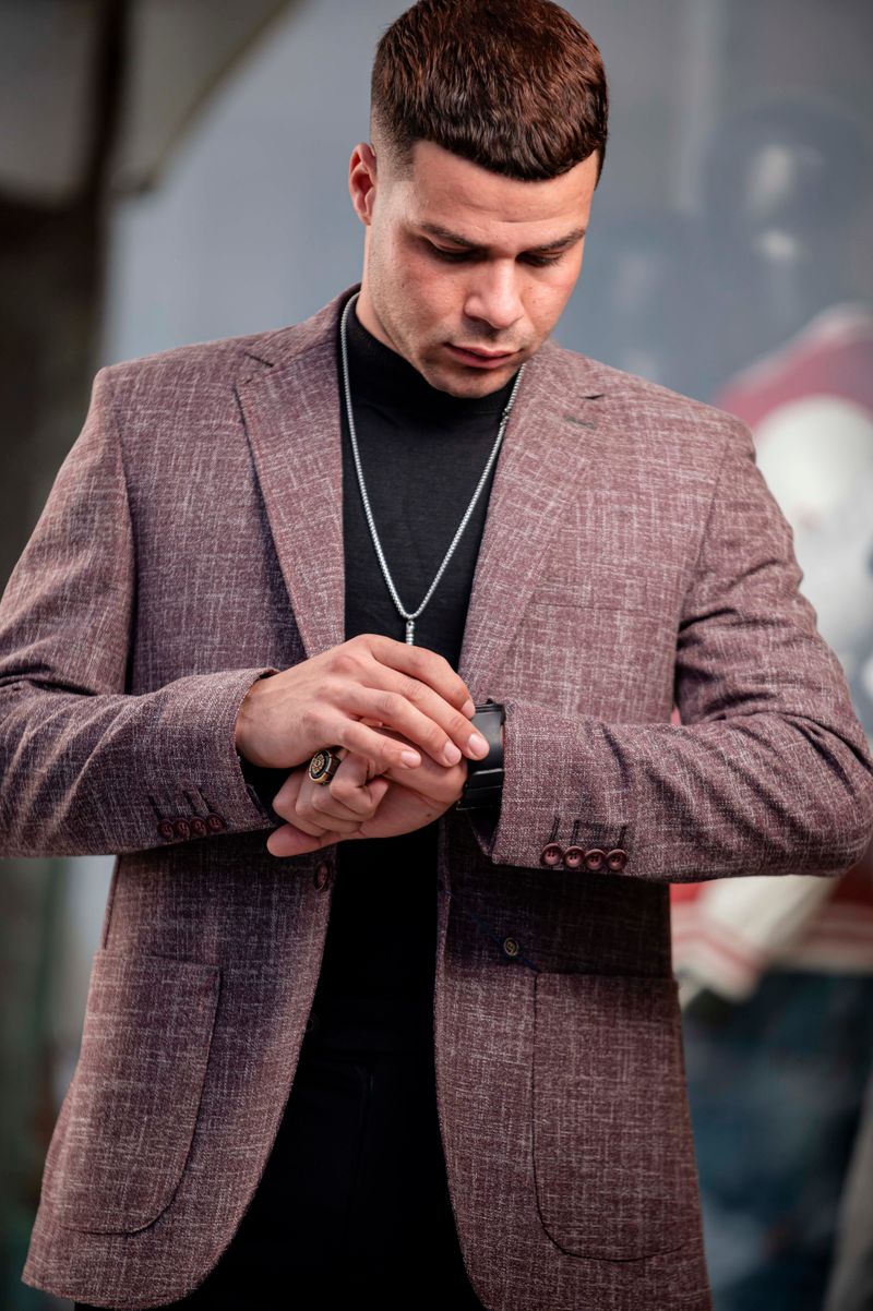 Elegant man in a trendy blazer glancing at his wristwatch.