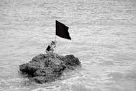 Woman on Rock Formation Holding a Flag