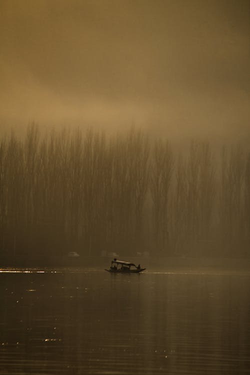 Silhouette of Boat on Lake in Mist