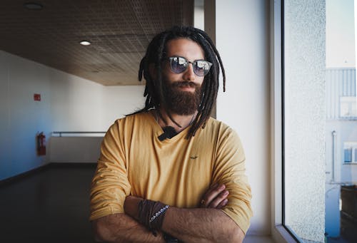 Man with Beard and Dreadlocks Standing by Window