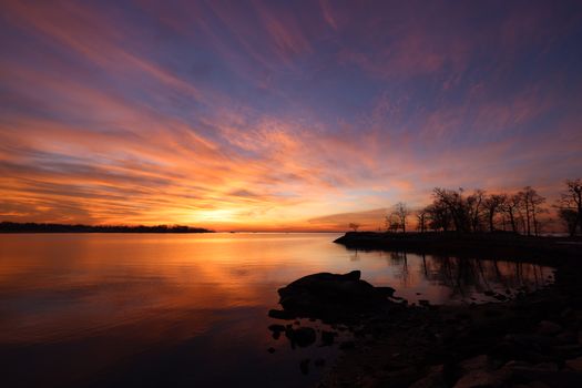 Beautiful sunset over a calm sea with vibrant sky colors reflecting on the water.