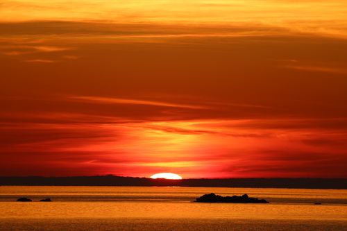 Free A breathtaking ocean sunset with vivid colors and a serene horizon, perfect for relaxing visuals. Stock Photo