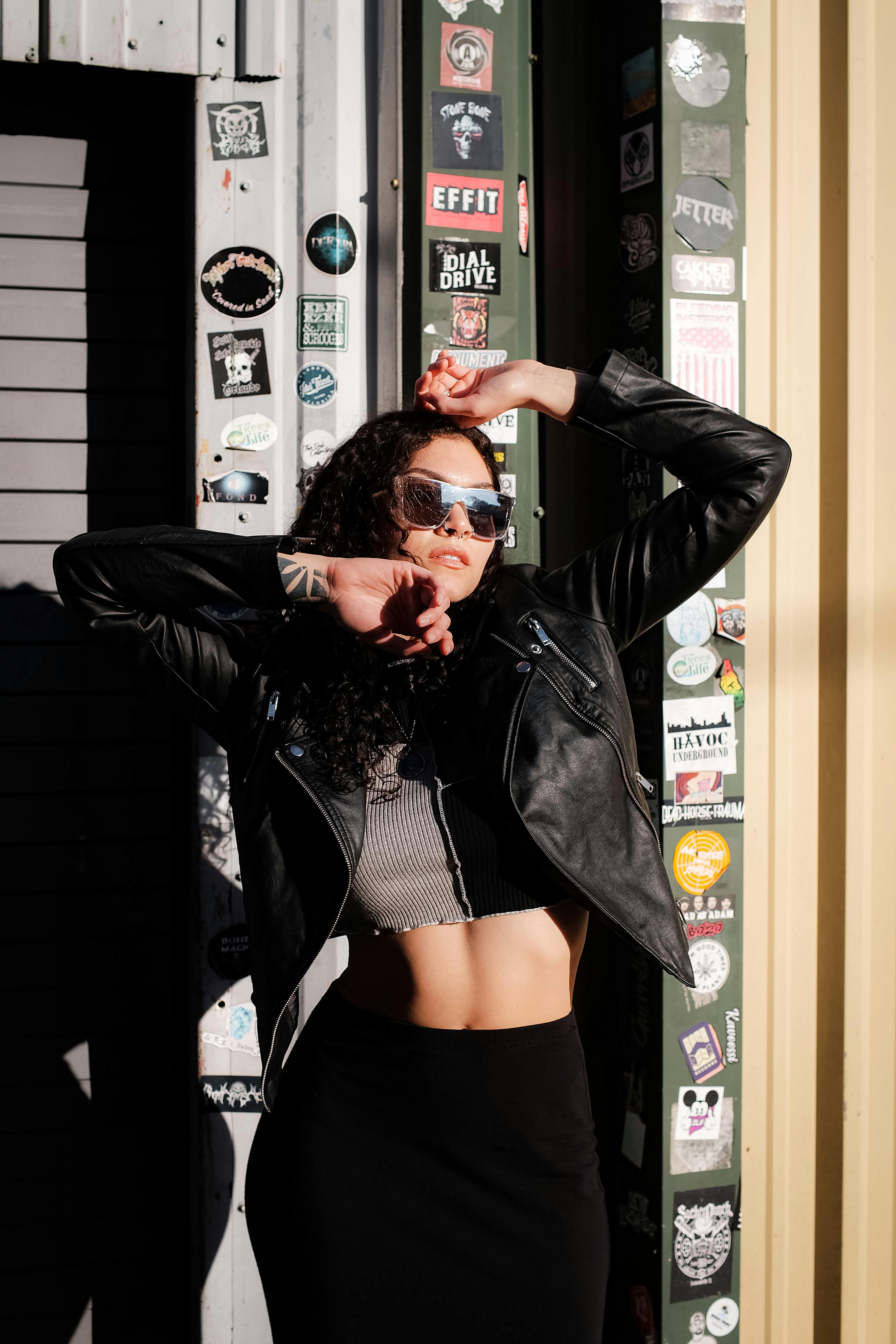 A guest wears sunglasses, a nekclace, a black leather jacket, a mesh  News Photo - Getty Images