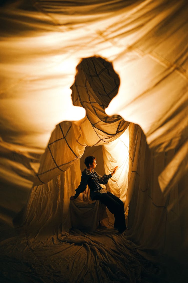 Woman Sitting In Fabric Posing In Studio 