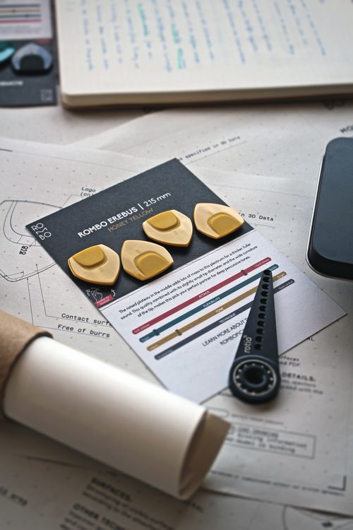 Free A creative setup featuring Rombo guitar picks and design materials on a desk. Stock Photo