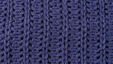 Detailed view of a blue knitted wool fabric with intricate weave pattern.