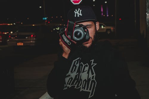 キヤノンデジタル一眼レフカメラを使用して写真を撮る男