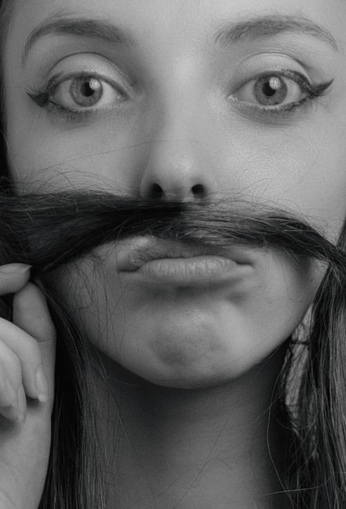 Free Close-up of a woman making a moustache with her hair, showcasing playful and funny expression. Stock Photo