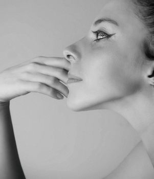 Close-up side view portrait of a woman with elegant pose in grayscale, showcasing facial expression and beauty.
