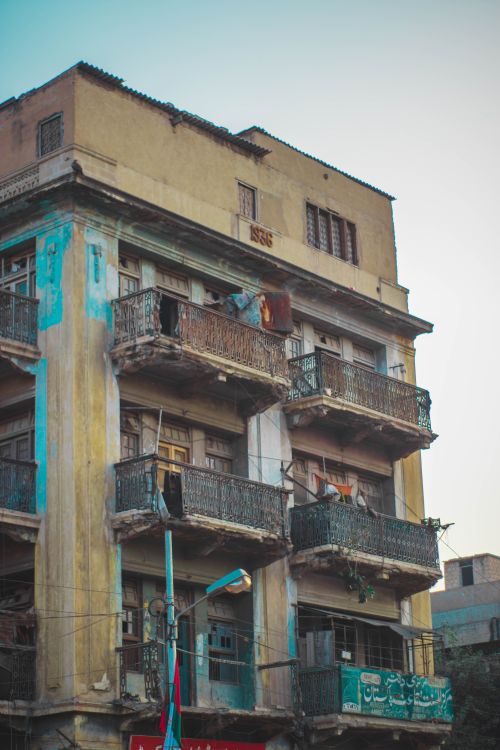 Free A vertical shot of a weathered, abandoned building with balconies, showing decay and neglect. Stock Photo