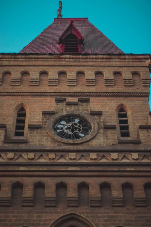 Free Low angle view of a historic building facade with intricate architecture and circular window. Stock Photo