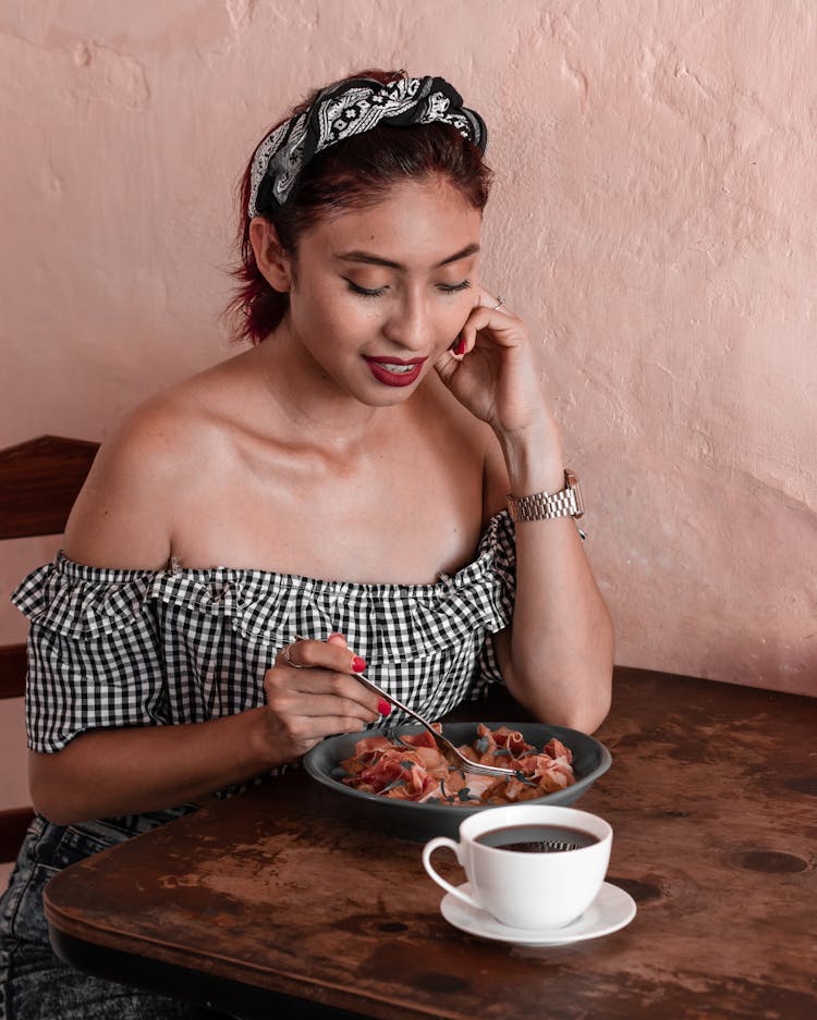 Woman Eating Food At Cafe Table