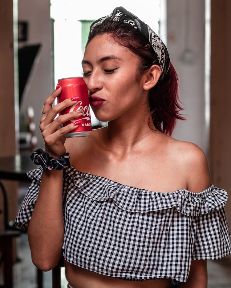 A Woman Holding A Coca-Cola In Can