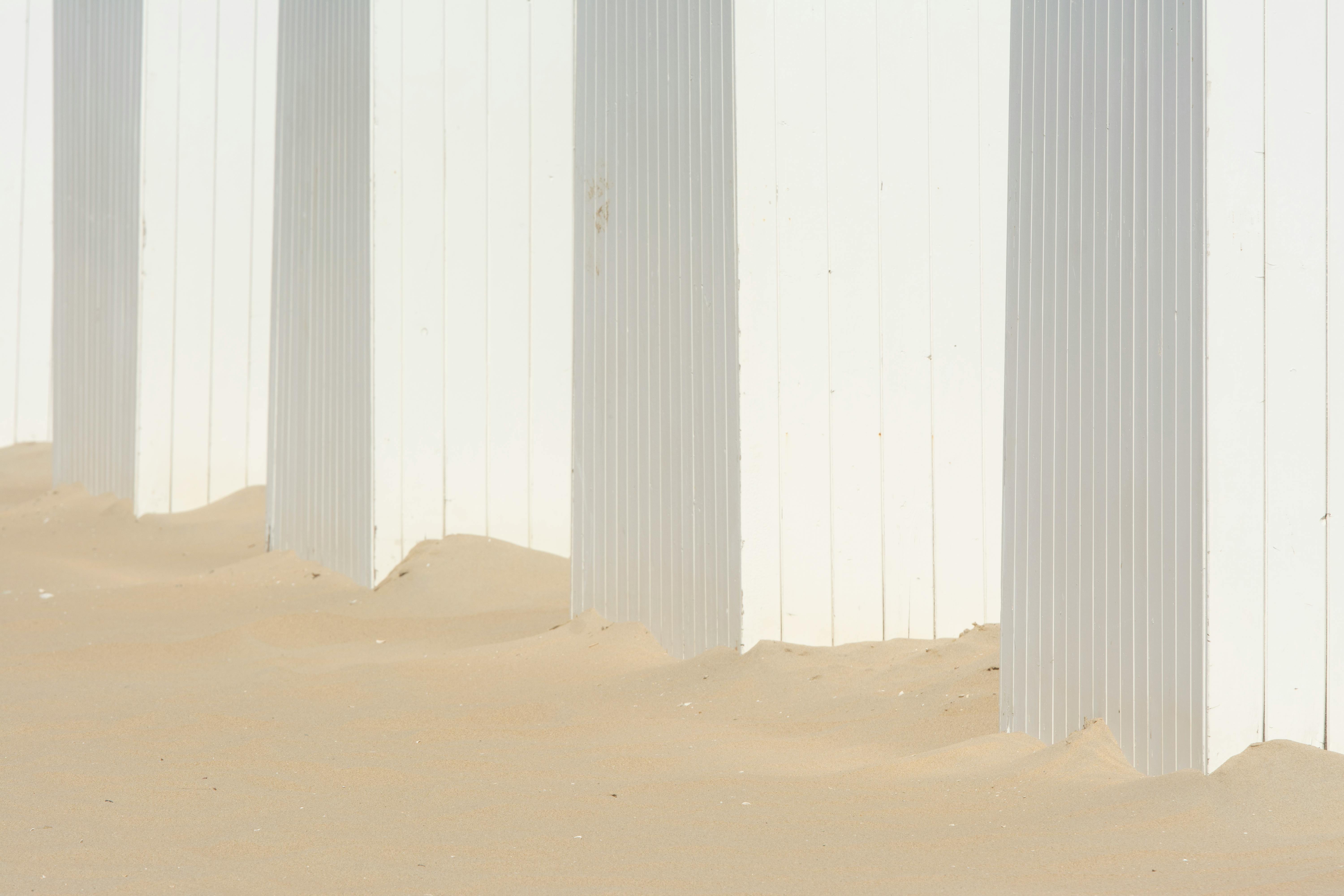 white and gray wooden wall on white sand