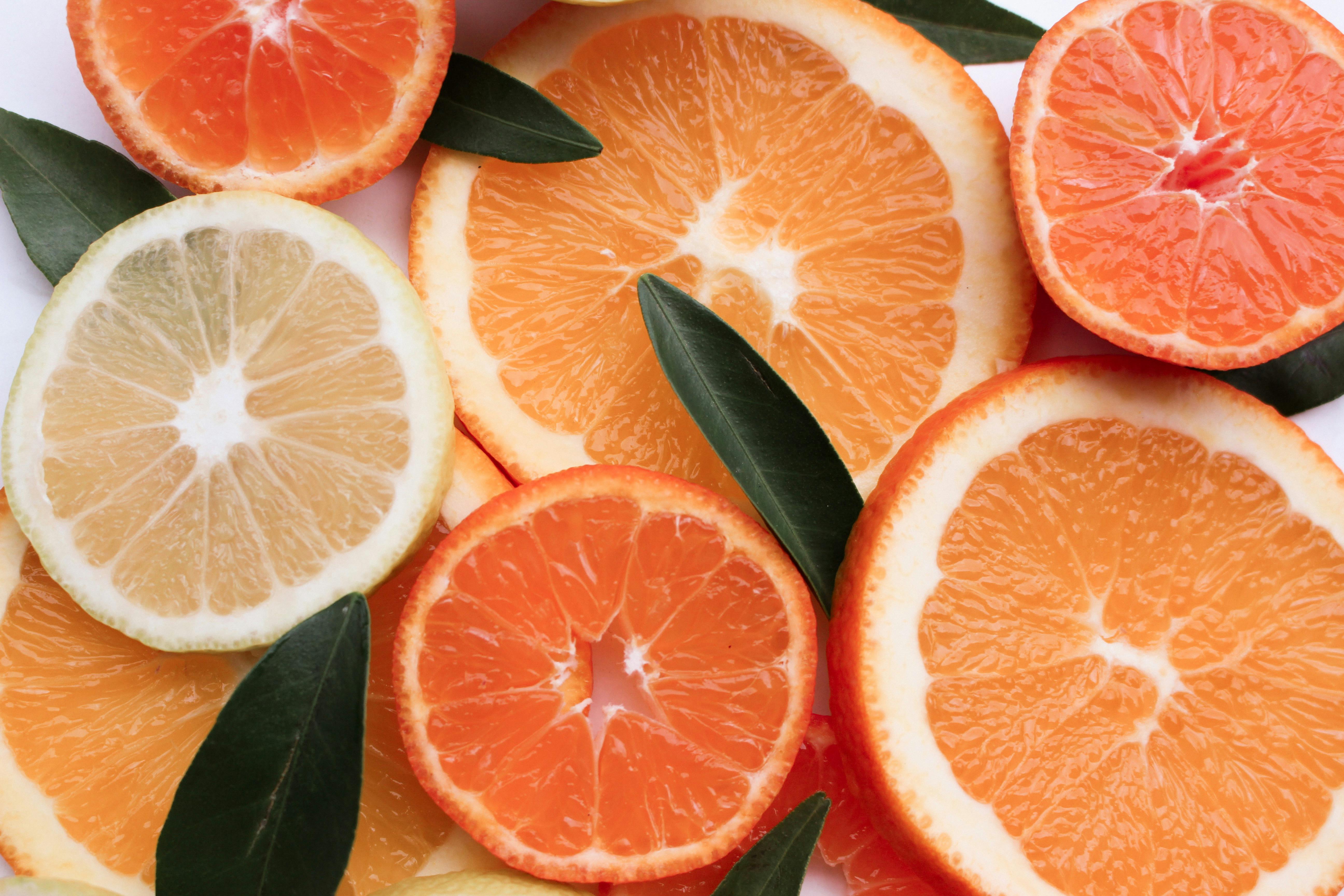 citrus fruits are arranged in a circle with leaves