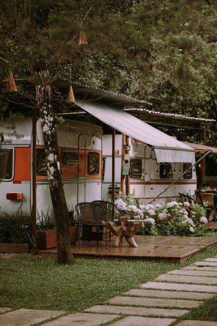 Charming outdoor caravan setup with a rustic awning and lush greenery for a perfect summer camping vibe.