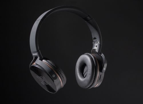 Free Close-up of wireless headphones on a dark background, showcasing design and texture. Stock Photo