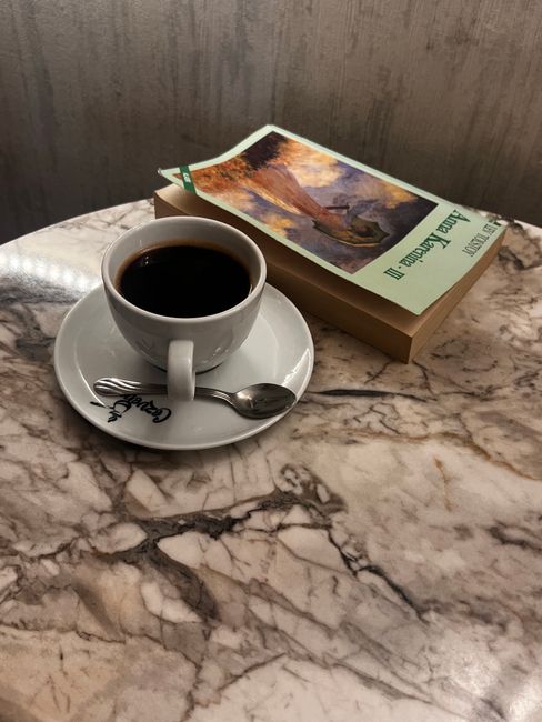 A cup of coffee and a book on a luxurious marble table, creating a cozy reading vibe.