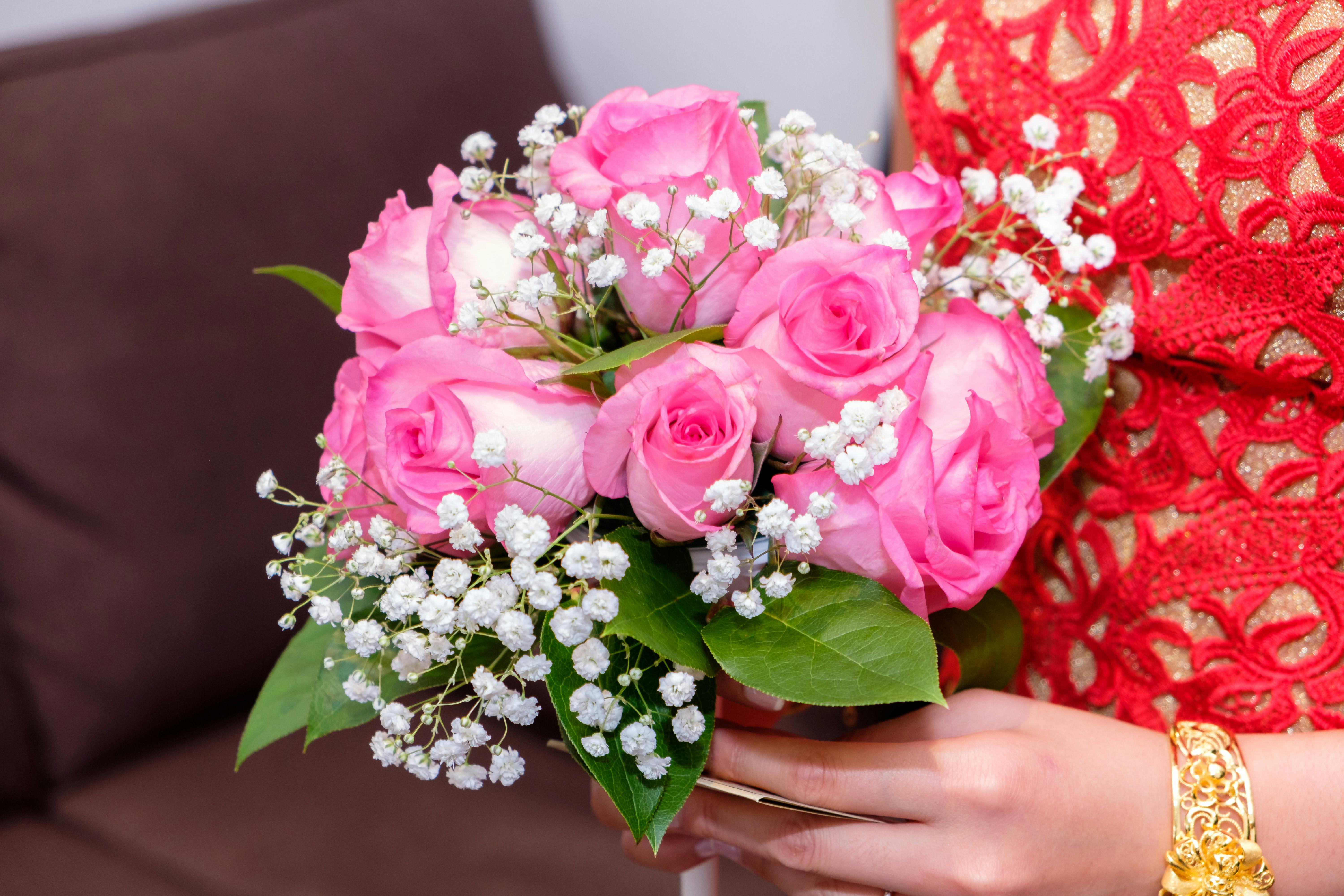 hands holding a bouquet of pink roses