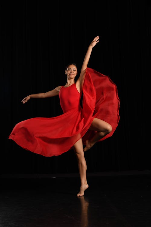 Photograph of a Woman in a Red Dress Dancing