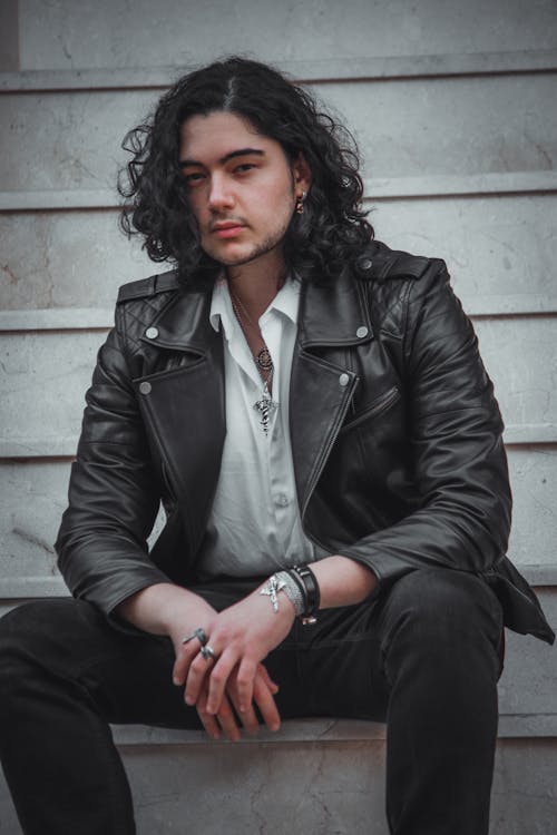 Man Wearing a Leather Jacket Sitting on the Stairs