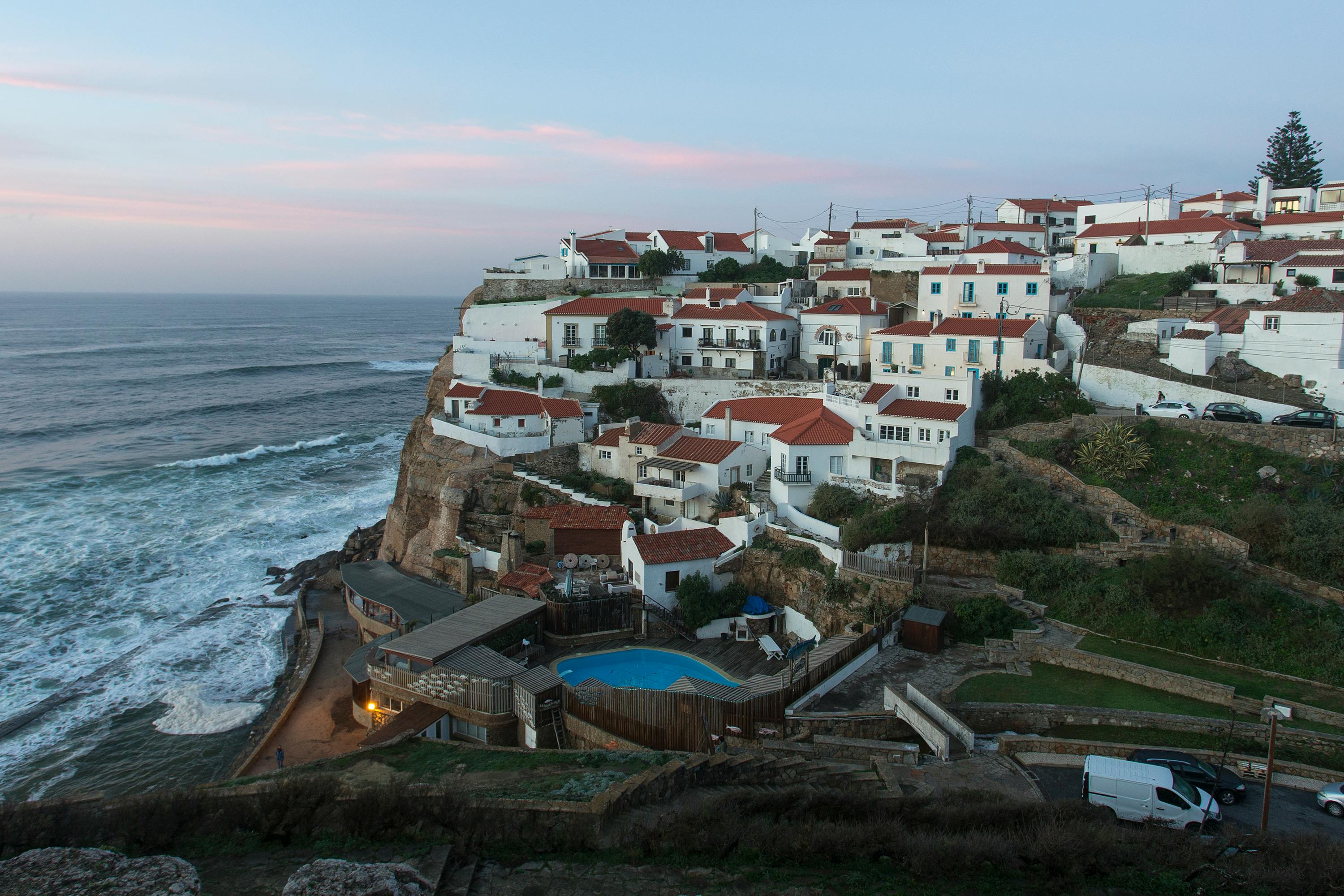 A picturesque view of Azenhas do Mar village perched on a cliff by the Atlantic Ocean in Portugal. - Azenhas do Mar