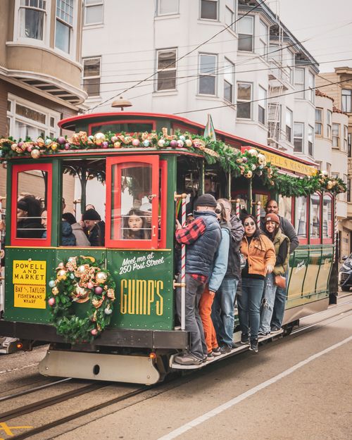 Free A lively San Francisco cable car filled with diverse passengers on a city street. Stock Photo
