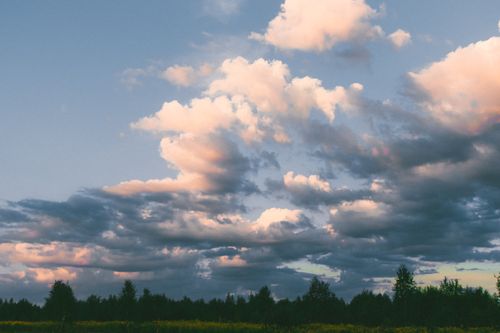 Free Serene rural landscape under a stunning cloudscape in summer, capturing nature's tranquility. Stock Photo
