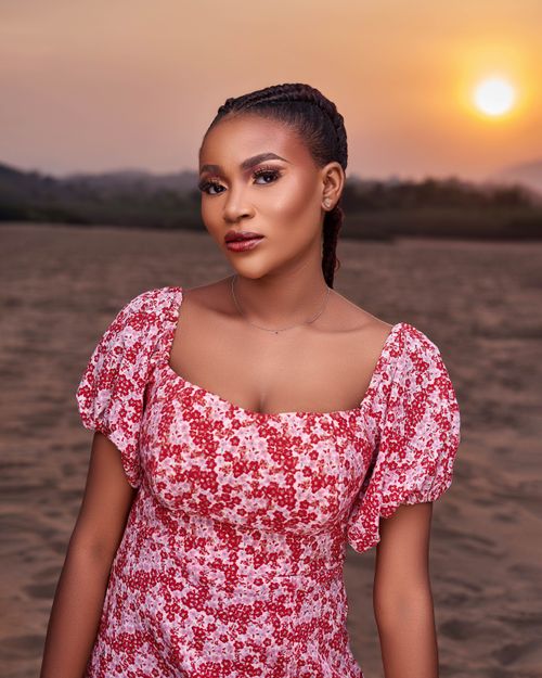 Free Beautiful portrait of a woman posing at sunset on a serene beach setting. Stock Photo