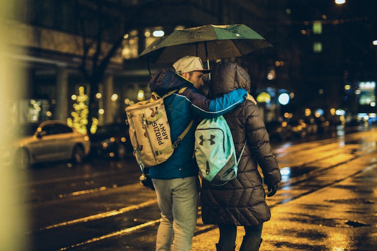 Couple Walking In Rain In City At Night 