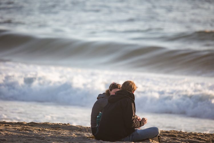 A Man And A Woman Talking At The Beach