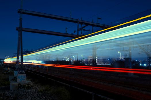 Long exposure of a train at night in London, capturing vivid light trails.