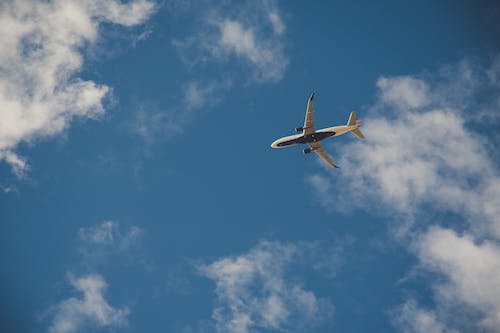 Free Worms Eye View of Airplane Flying on Sky Stock Photo