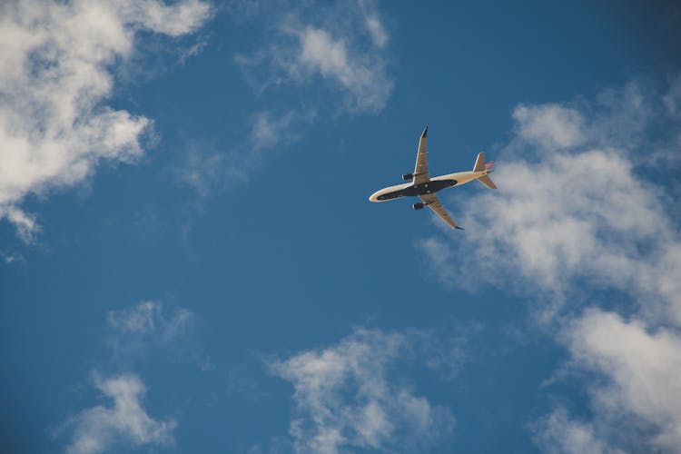 Worms Eye View Of Airplane Flying On Sky