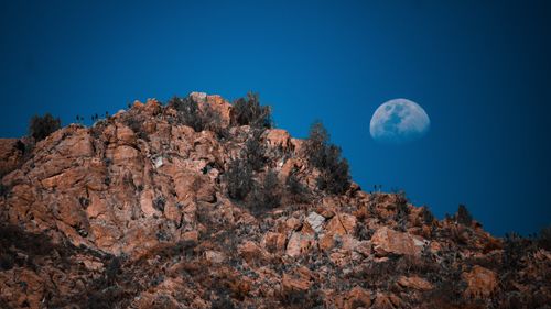 Free Scenic view of the moon rising over rocky Andes mountains in Santiago, Chile. Stock Photo