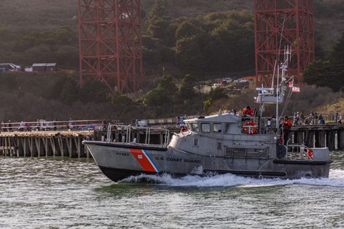 Free US Coast Guard boat patrolling with Golden Gate Bridge background. Stock Photo