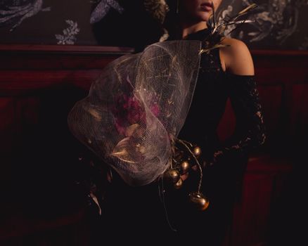 Moody portrait of a woman in formal attire holding a floral bouquet.